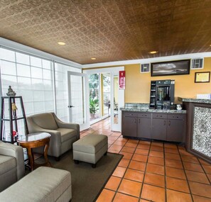 A hotel lobby with a seating area, a kitchenette, and a large window providing a view of the outdoors. - Econo Lodge Cocoa Beach - near the Port (Cocoa Beach)