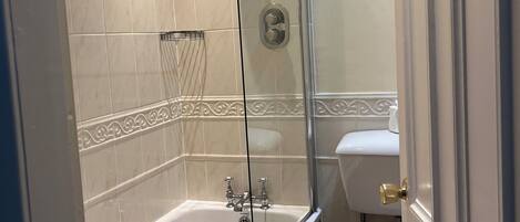 A bathroom with a bathtub, shower, toilet, and sink.