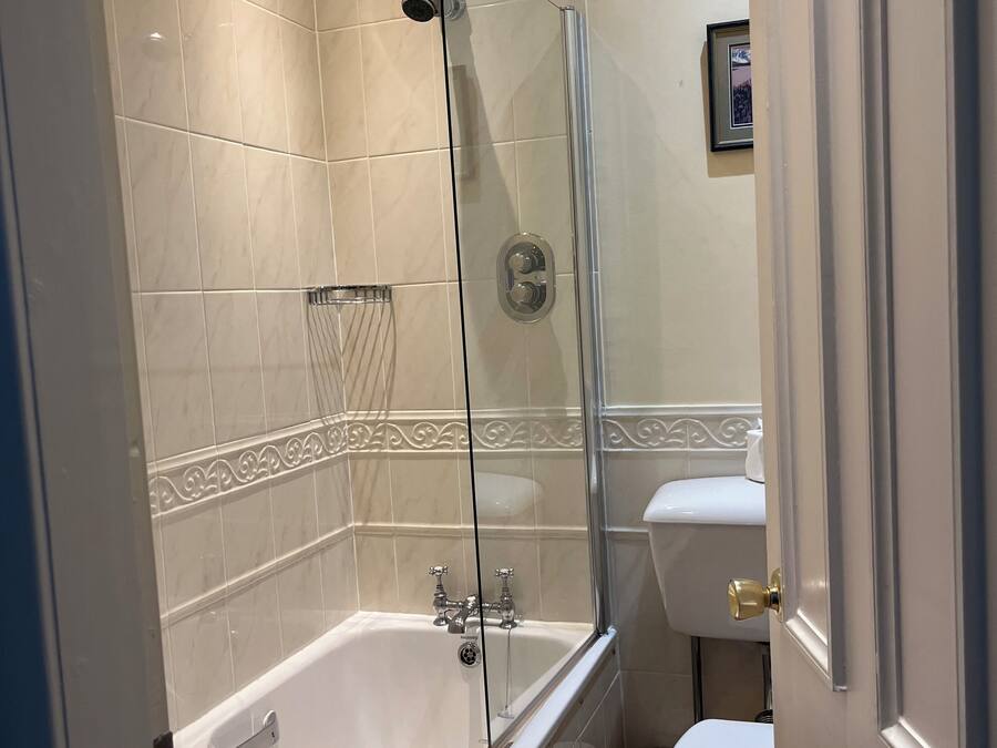 Un baño con bañera, ducha, inodoro y lavamanos.