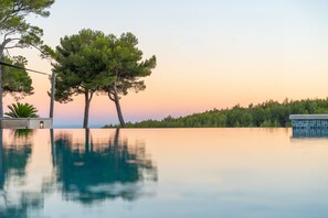 A serene pool area with a clear view of the surrounding trees and a distant forest. - Hôtel & Spa du Castellet (Le Castellet)
