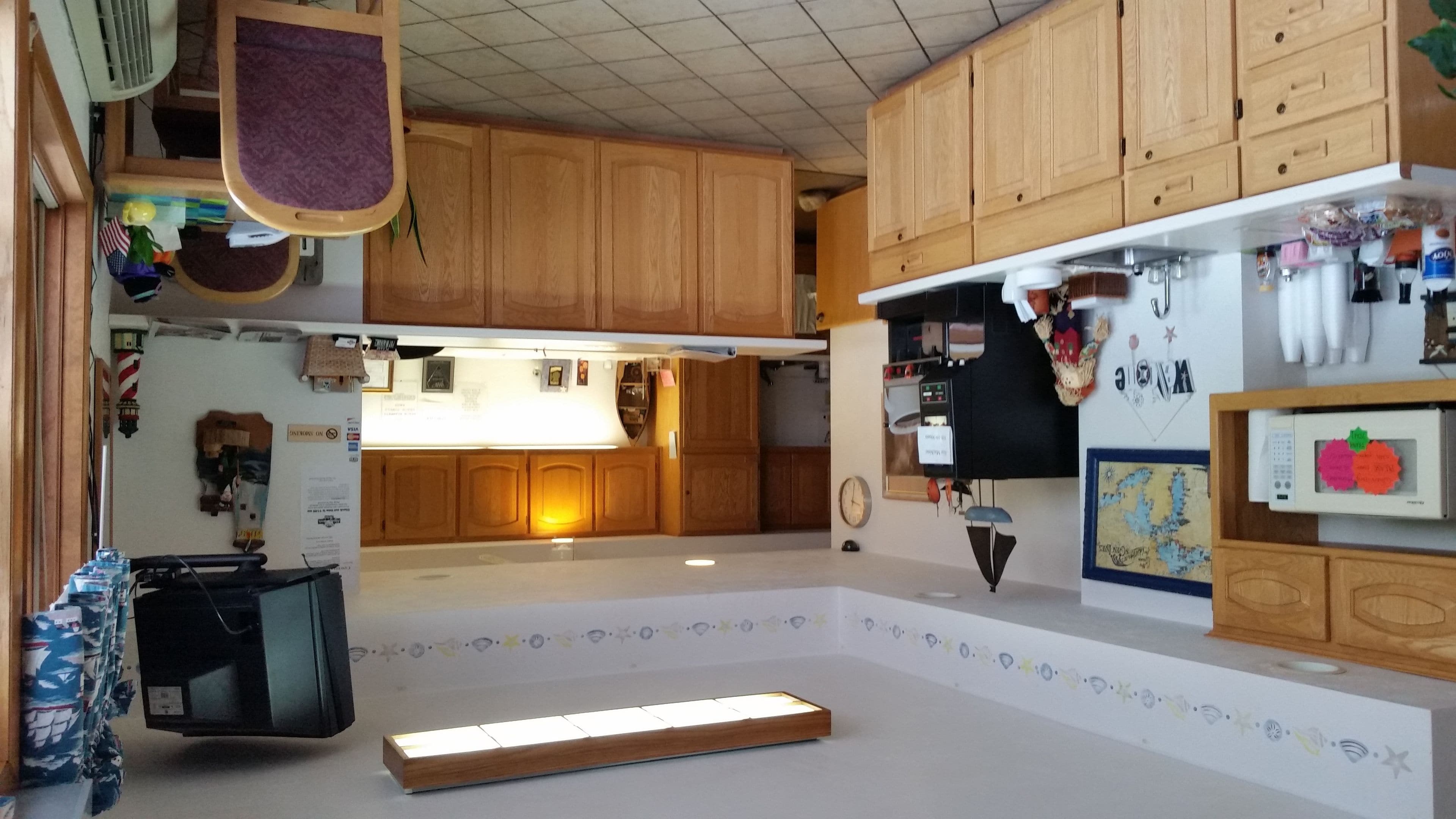 Una cocina con armarios de madera, microondas y una pequeña isla.