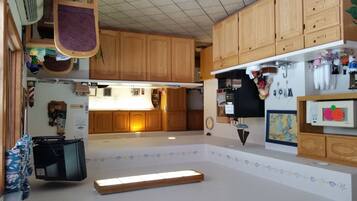 Una cocina con armarios de madera, microondas y una pequeña isla.