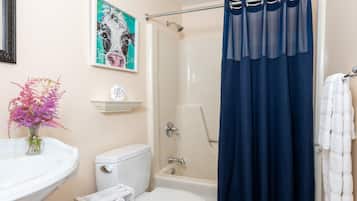 A bathroom with a toilet, bidet, and shower curtain.