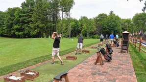 A golf course with a brick pathway, wooden boxes, and a tee box. - Centennial House (Northfield)