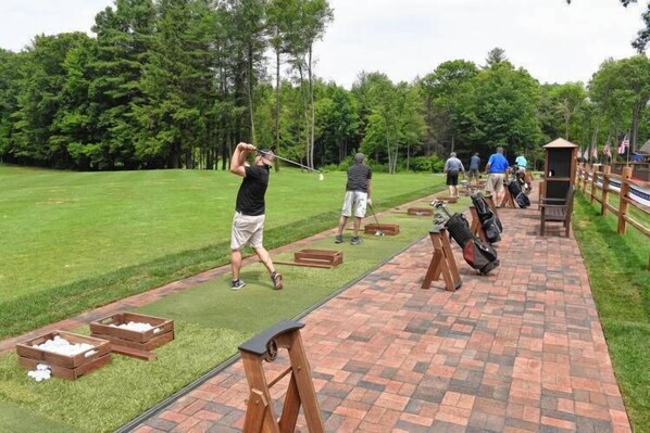 A golf course with a brick pathway, wooden boxes, and a tee box. - Centennial House (Northfield)