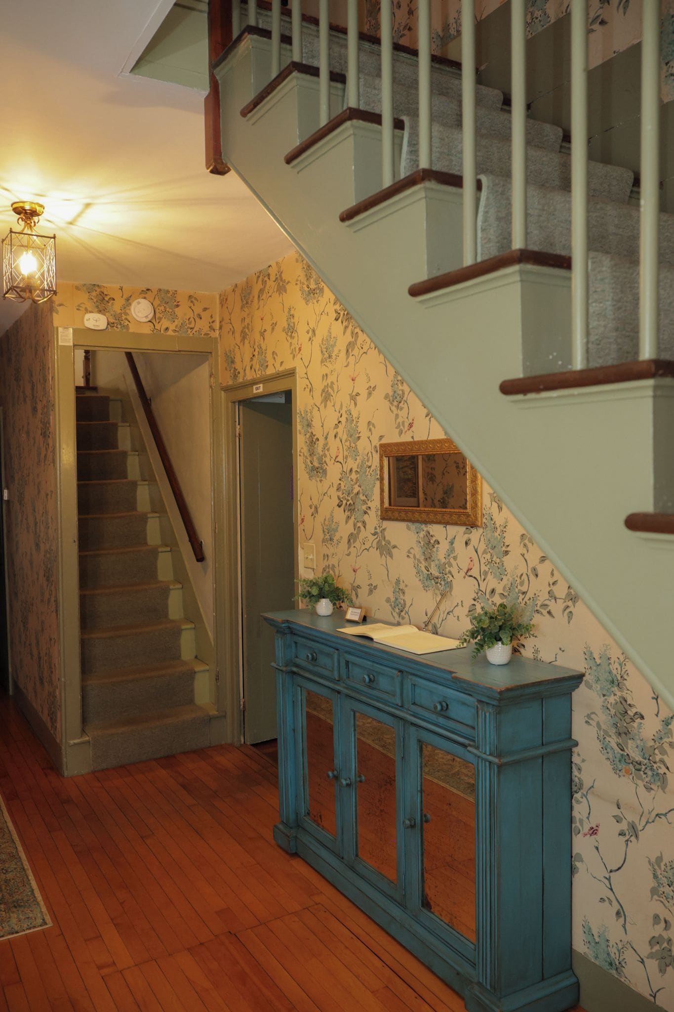 A staircase with wooden railings and a blue cabinet with drawers.