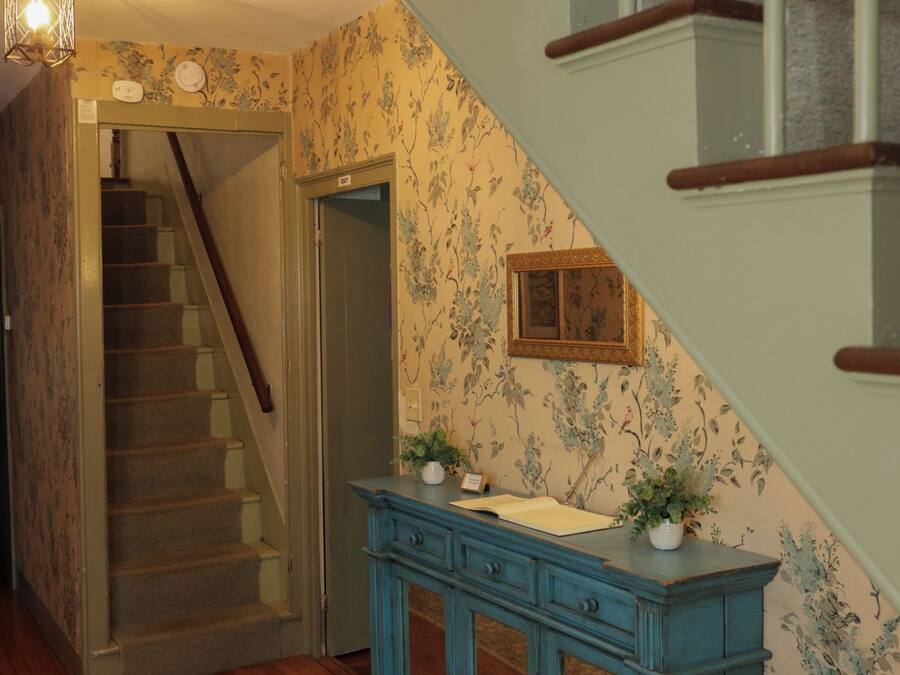 A staircase with wooden railings and a blue cabinet with drawers.