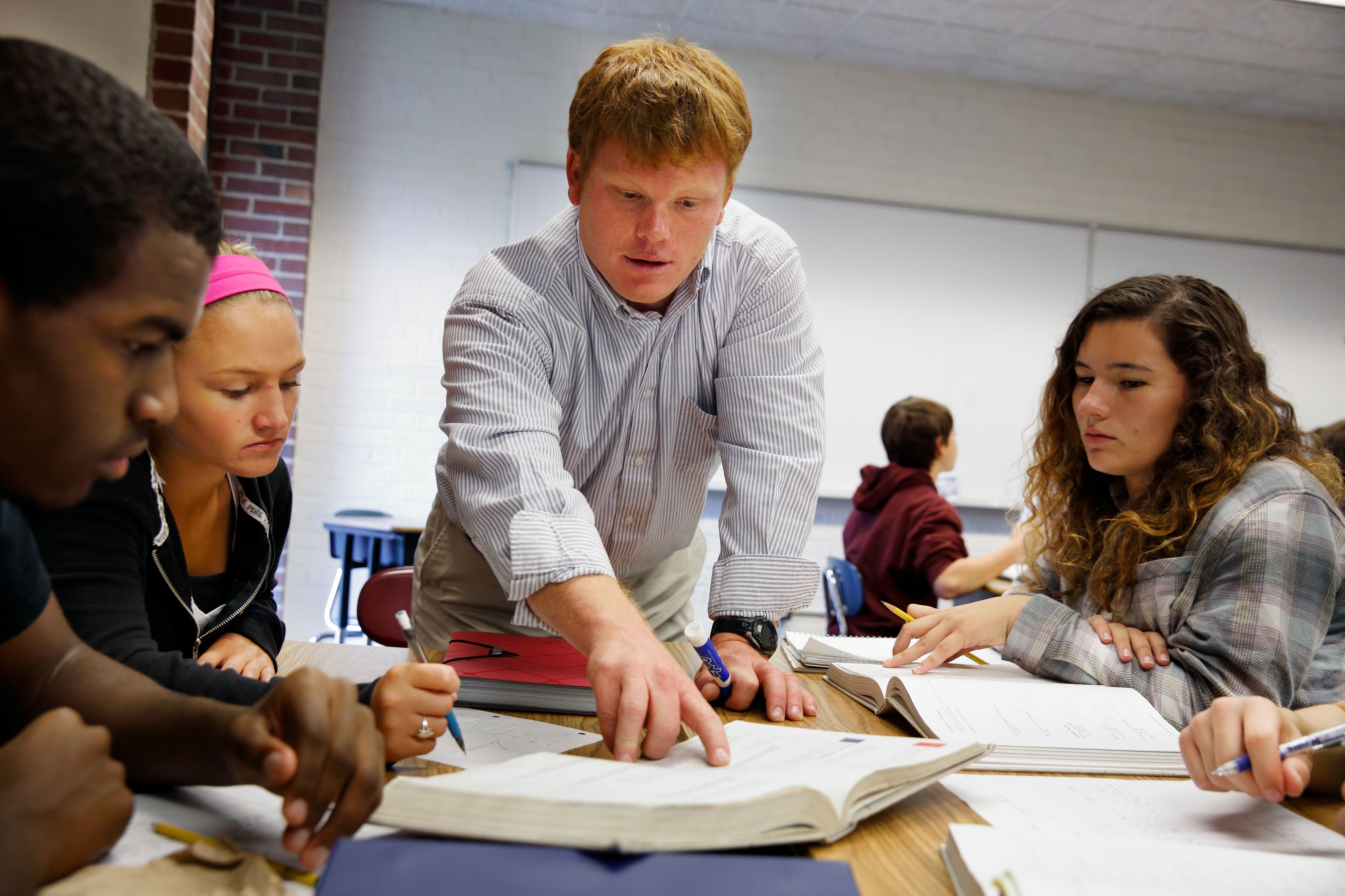 A classroom with students engaged in a study session, featuring desks, chairs, and educational materials.