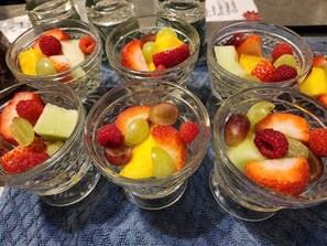 Une table sur laquelle se trouvent plusieurs petits bols en verre remplis de différents fruits.