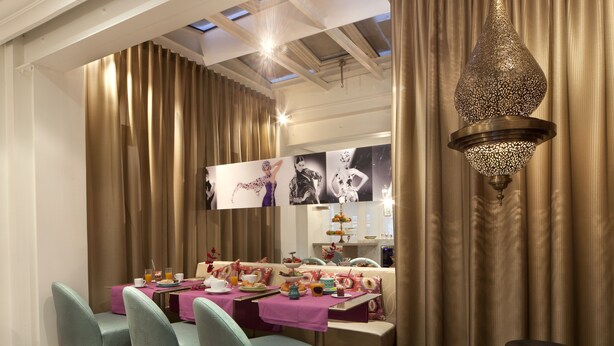 A dining area with a table set for breakfast, featuring a variety of dishes and drinks. - Hotel Mayet (Paris)