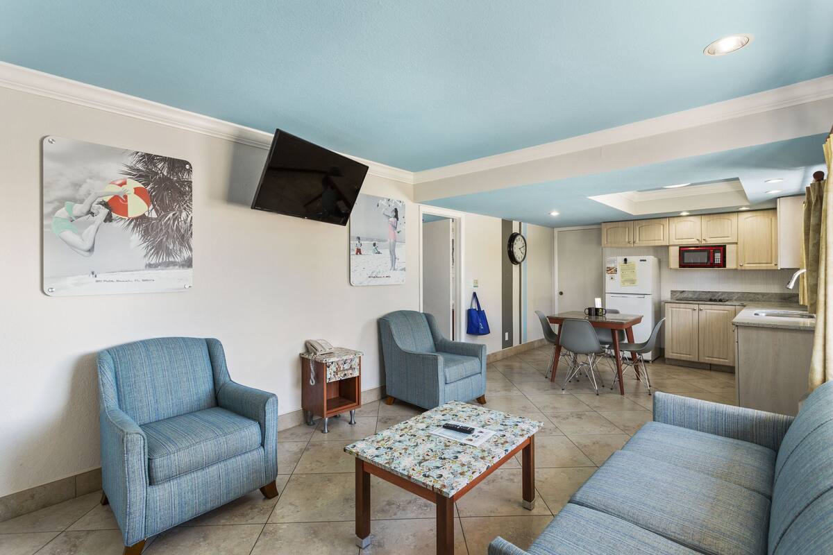 A living room with two armchairs, a coffee table, and a dining area with a table and chairs.