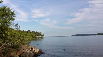 A calm lake with a rocky shoreline and trees.
