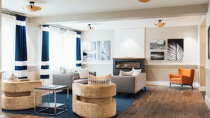 A modern living room with a sofa set, a coffee table, and a fireplace. - Belfast Harbor Inn (Belfast)