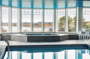 Zona de piscina con vistas a un lago y montañas.