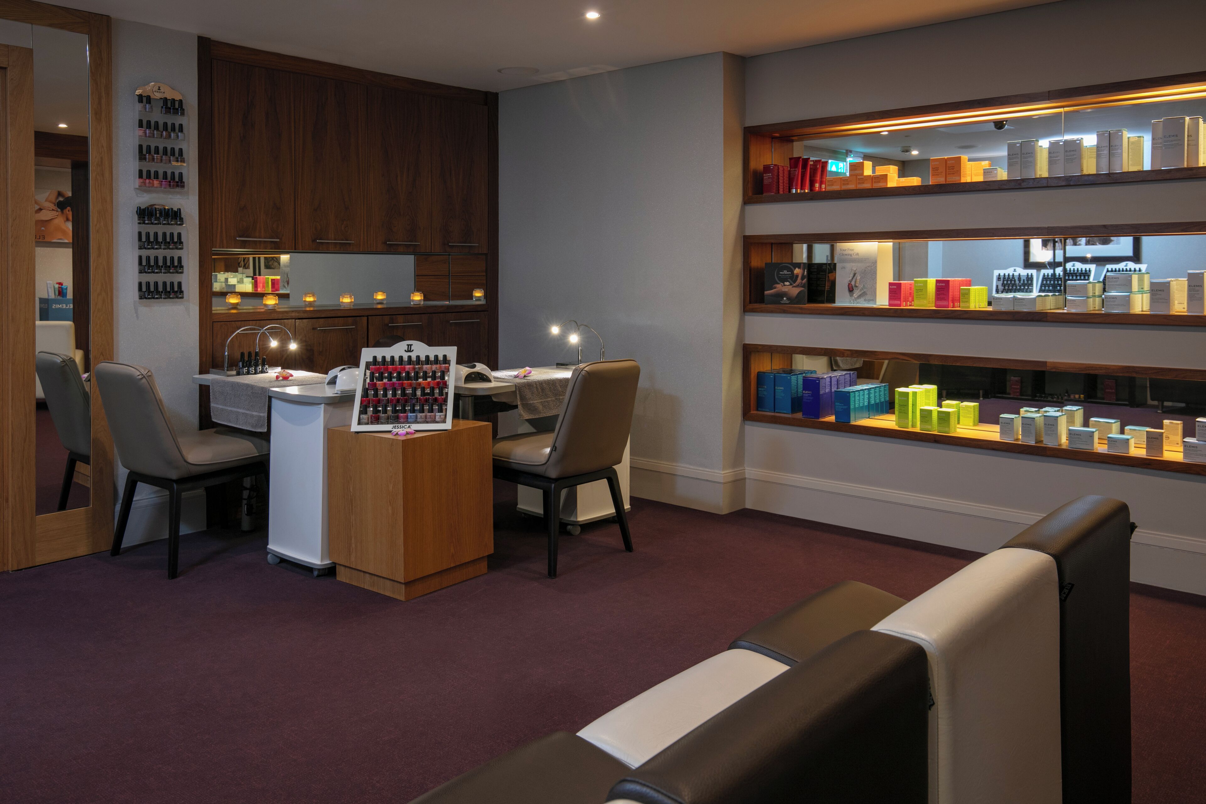 A modern interior with a desk, chairs, and shelves displaying various products.