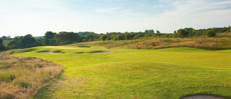 Ein Golfplatz mit Sandbunkern und blauem Himmel.