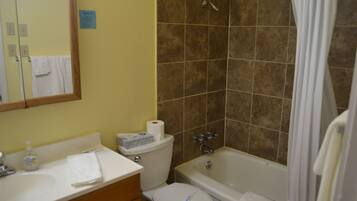Une salle de bain équipée d’un lavabo, de toilettes, d’une baignoire et d’une douche.