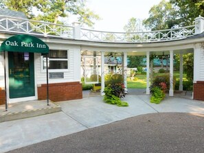 L’extérieur de l’hôtel Oak Park Inn se caractérise par une entrée abritée, une façade en briques et un agréable espace porche.