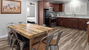 A kitchen with wooden cabinets, a stainless steel refrigerator, a microwave, and a sink.