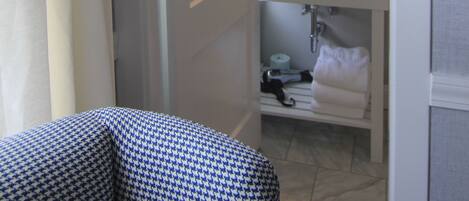 A bathroom with a white sink, a mirror, and a towel rack.