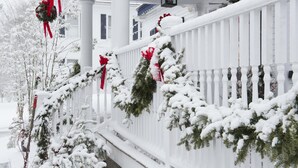 A snow-covered porch with white railings and red bows. - Kennebunkport Inn (Kennebunkport)