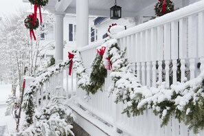 A snow-covered porch with white railings and red bows. - Kennebunkport Inn (Kennebunkport)