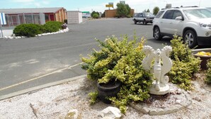 A parking lot with a white pickup truck, a white SUV, and a building with a sign that says "CAFE". - Knights Inn Boardman (Boardman)