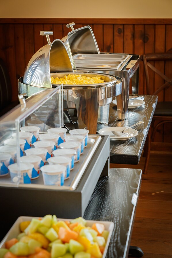 A buffet setup with various food containers and utensils.