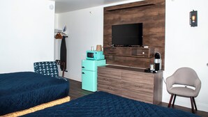 A hotel room with two beds, a TV, a microwave, a coffee maker, and a chair. - Flagship Inn and Suites (Boothbay Harbor)