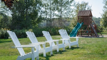 Relax in a serene natural setting surrounded by lush greenery and a wooden play structure.