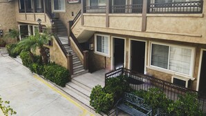 A two-story building with a sign reading "Nite Inn." It features a staircase, multiple windows, and a balcony with a metal railing.