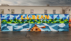 Un mural colorido con la palabra "LOBEAN" y un diseño de kayak en un edificio.