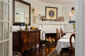 Un comedor con chimenea, un alero de ladrillo blanco y un sello enmarcado de la Casa Blanca.
