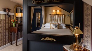 A room with a large bed, a mirror, a dresser, and a sign reading "Northern Pacific Railroad". - A Williamsburg White House (Williamsburg)