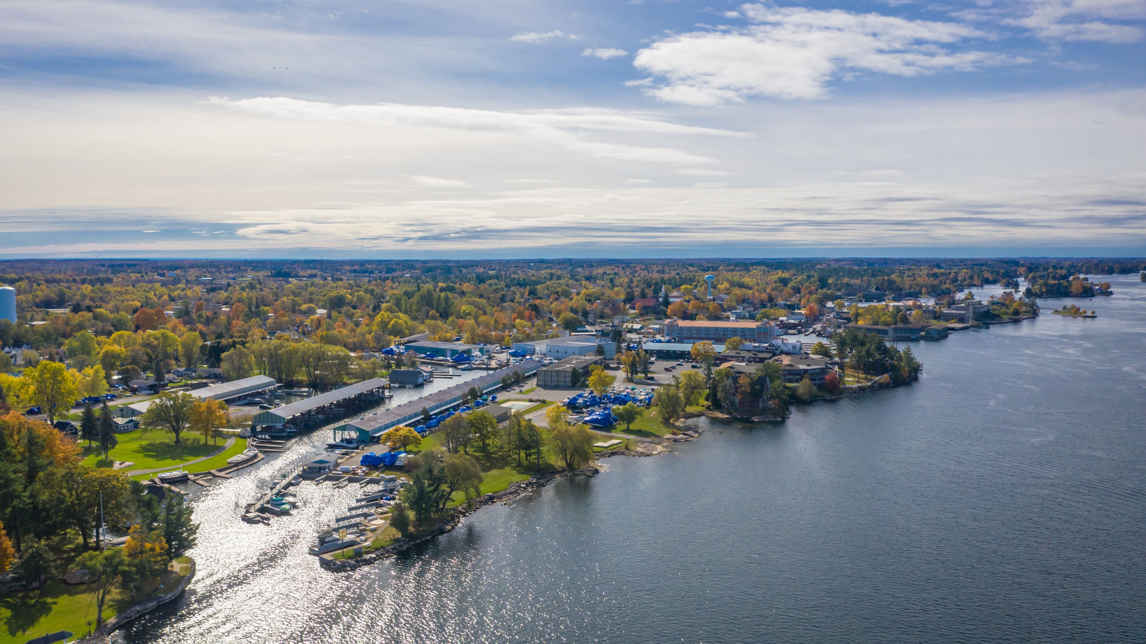 Ein Blick von oben auf eine Flussstadt mit einem Yachthafen, Gebäuden und Herbstlaub.