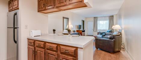 A modern kitchen with wooden cabinets, a built-in refrigerator, and a central island.