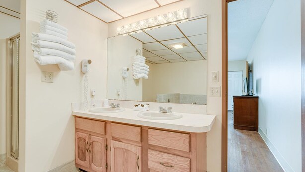 Une salle de bain moderne avec deux lavabos, un grand miroir et des meubles en bois.