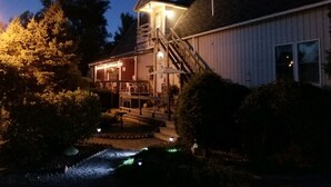 Ein zweistöckiges Gebäude mit einer Veranda und einer Treppe, die zu der oberen Etage führt.