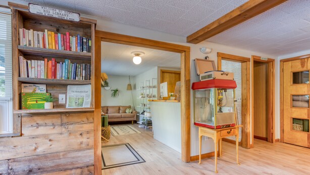 Una biblioteca acogedora con estanterías de madera, un rincón de lectura y una chimenea.