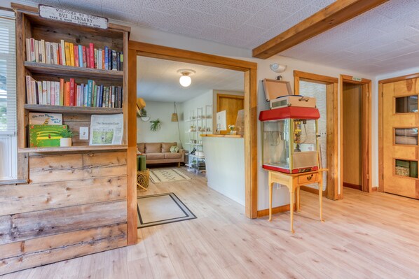 Una biblioteca acogedora con estanterías de madera, un rincón de lectura y una chimenea.