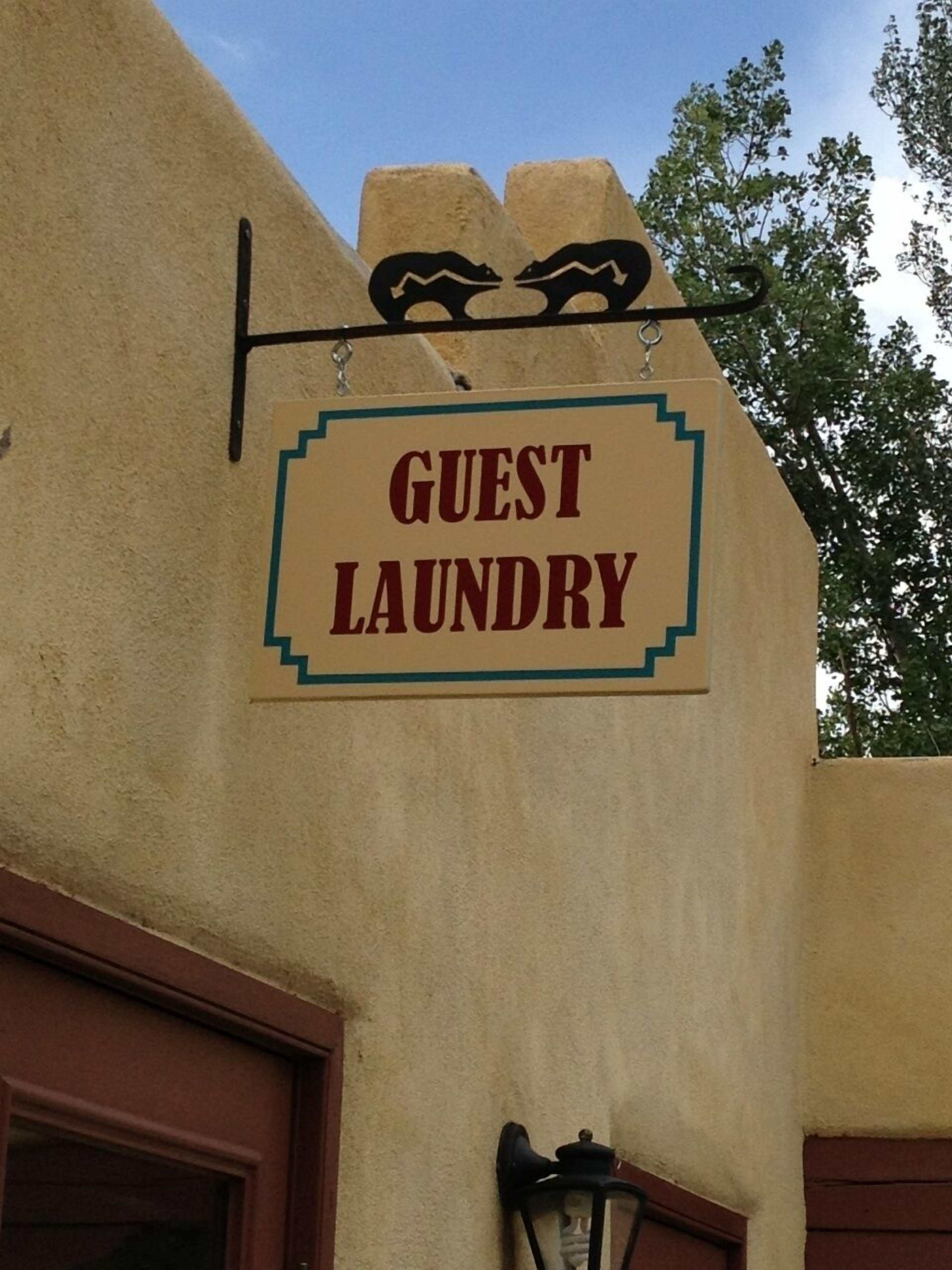 Segnaletica per 'Guest Laundry' fissata a un edificio.