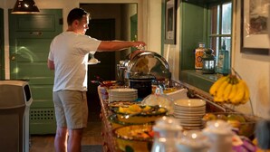 A buffet setup with various dishes and a person serving food. - El Pueblo Lodge (Taos)
