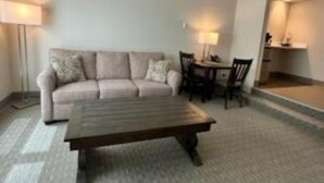 Ein Wohnzimmer mit einer Couch, einem Couchtisch und einem Esstisch mit Stühlen.