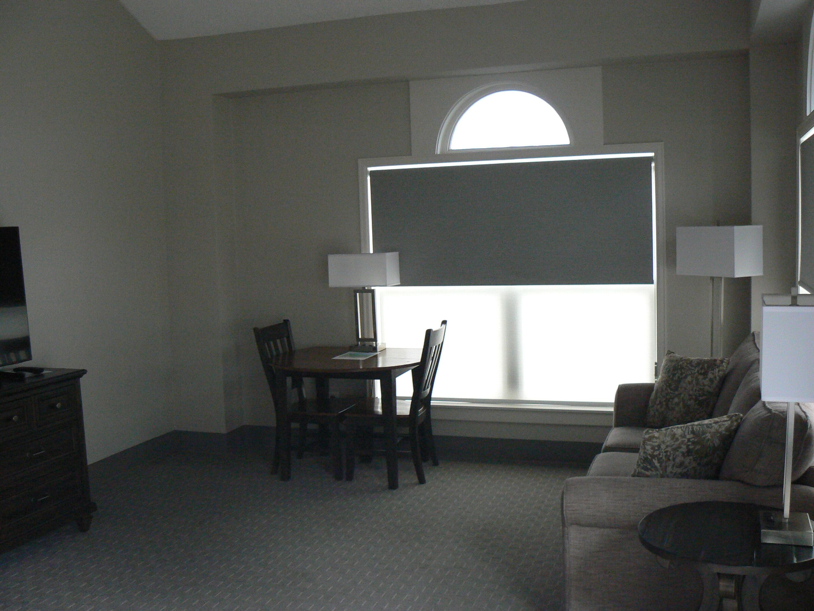 Una habitación con una mesa de comedor, sillas, un sofá, un televisor y una ventana con vistas.