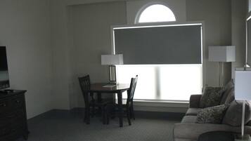 Una habitación con una mesa de comedor, sillas, un sofá, un televisor y una ventana con vistas.
