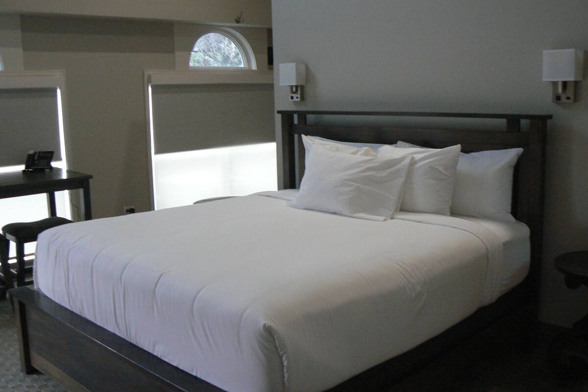 Une chambre d’hôtel avec un grand lit, un bureau et une fenêtre.