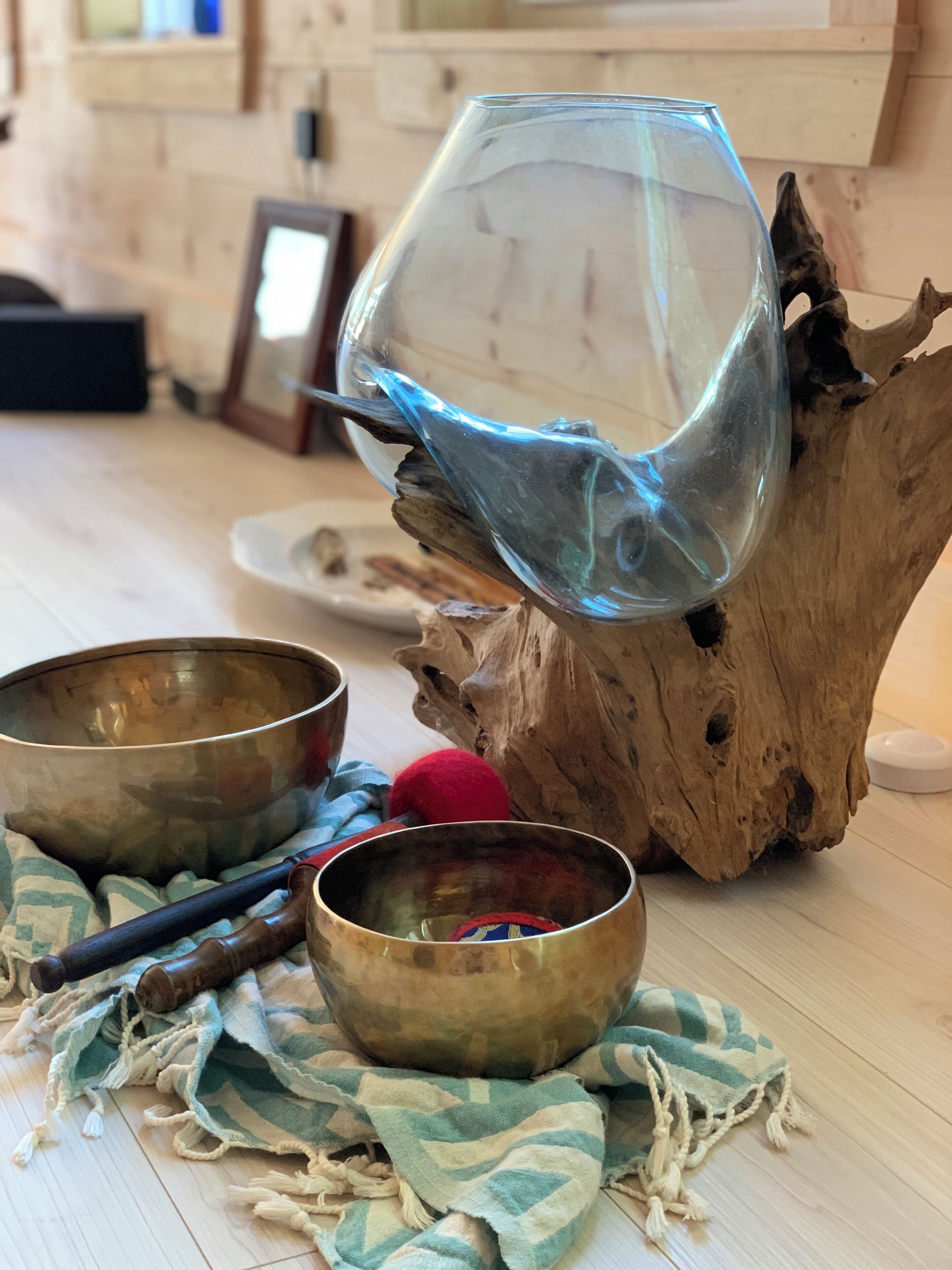 Une table en bois avec deux bols, un verre et une balle rouge.