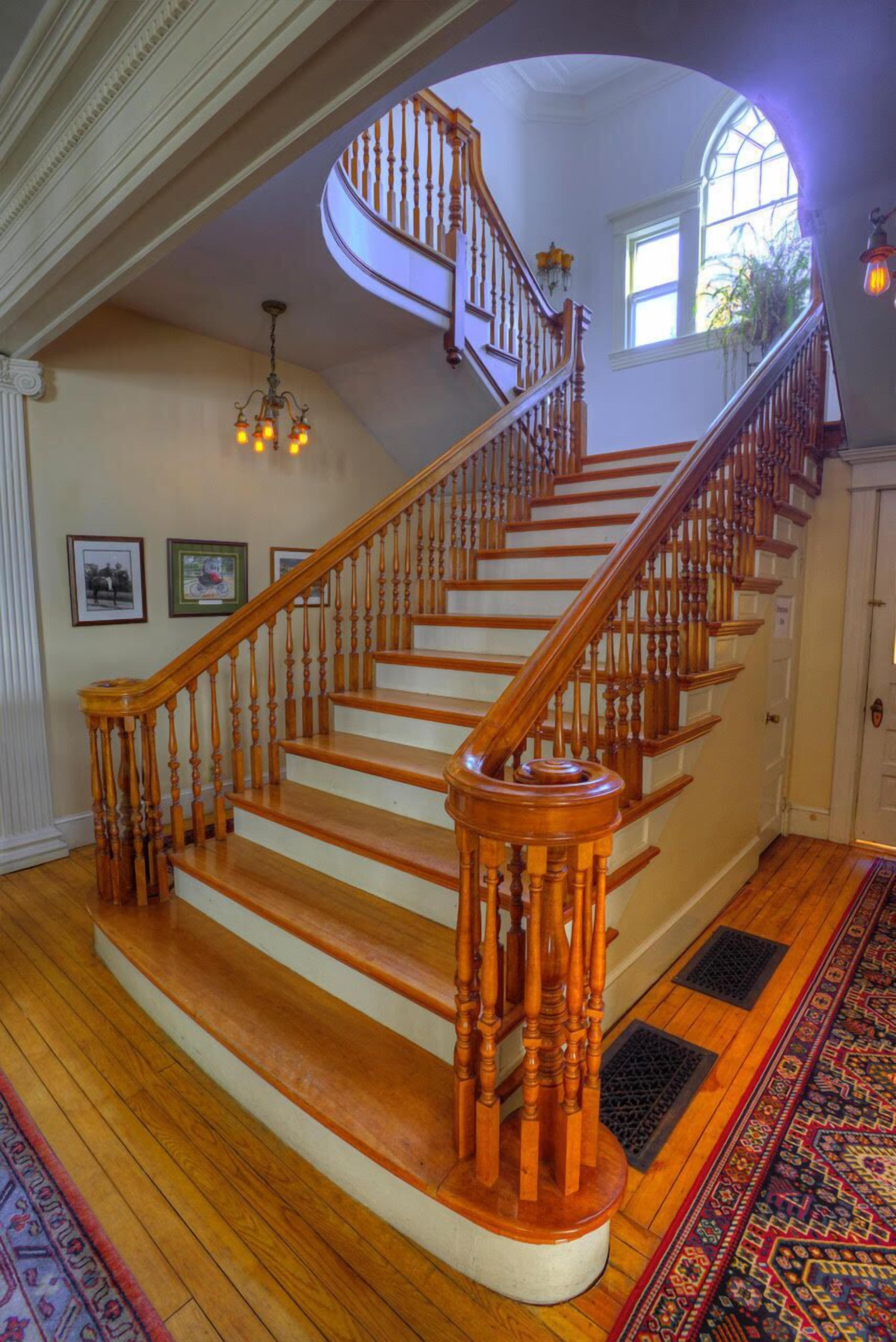 Un magnifique escalier en bois, doté de balustrades et d’une conception incurvée, menant à l’étage supérieur.