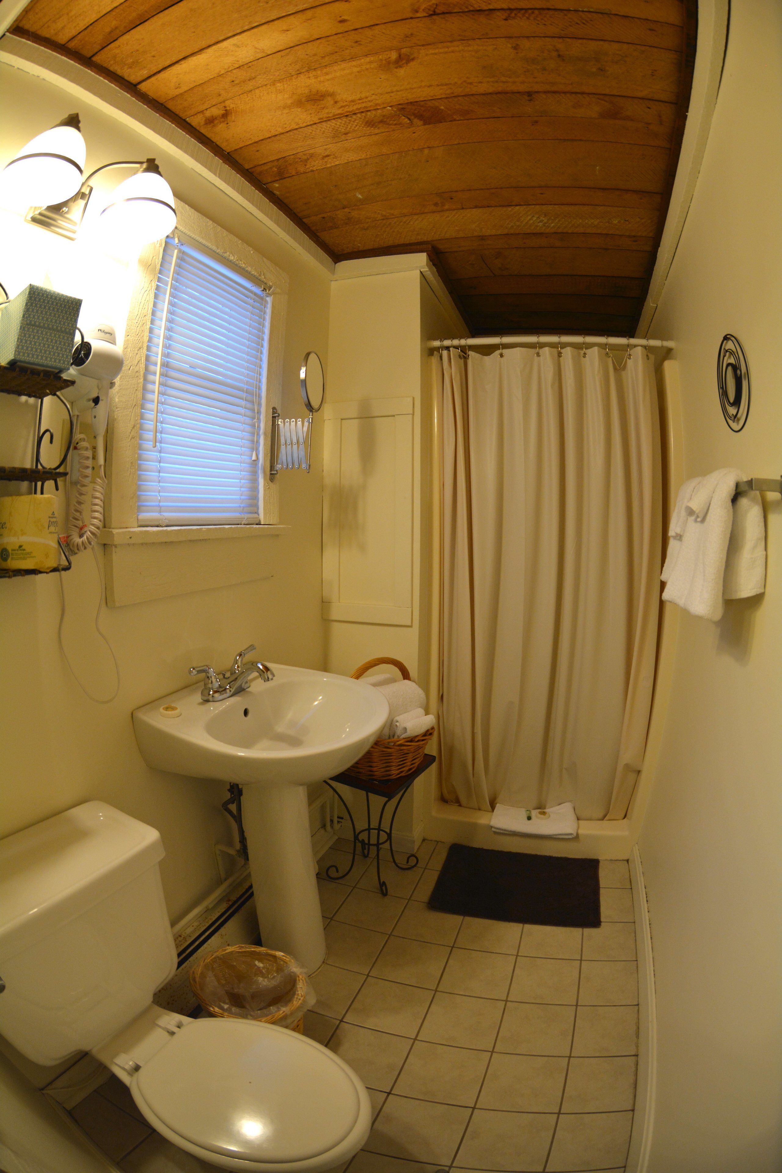 A small bathroom with a toilet, sink, and shower curtain.