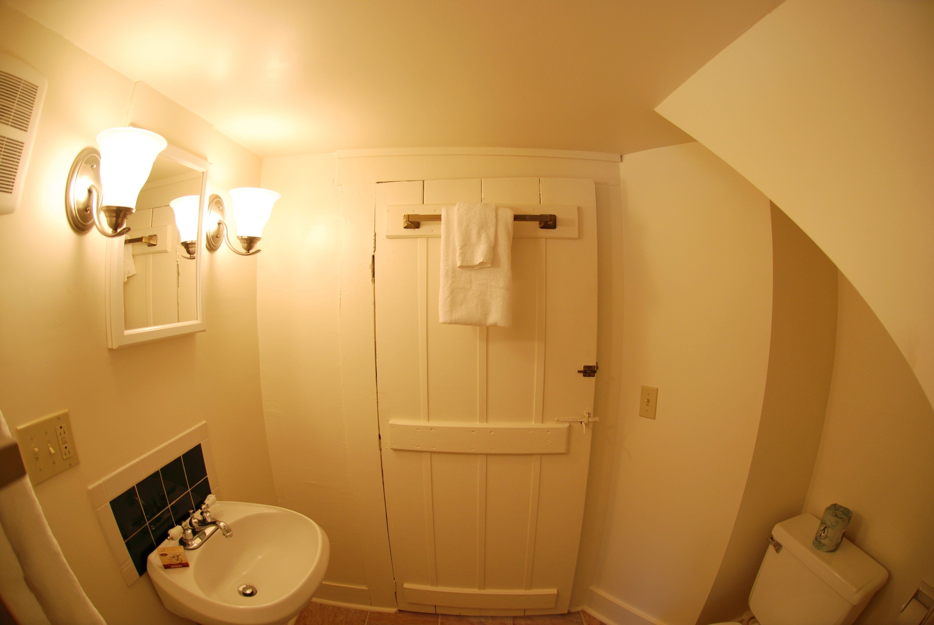 A bathroom with a sink, mirror, and towel rack.